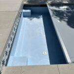 20x45 Pool Showing the light blue stucco finish, along with the patterned tiles. This pool is topped with a grey pool automatic liner.
