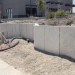 Unfinished EPS foam retaining wall installed along commercial lot in Saratoga Springs