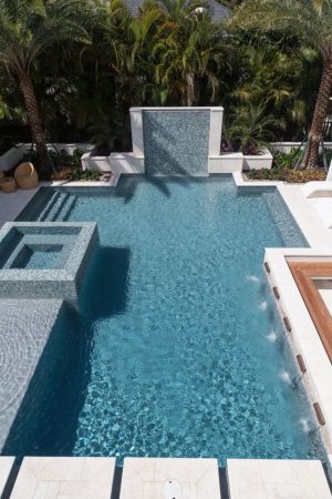 Luxury pool with cascading waterfalls, integrated spa, and a panoramic countryside view.