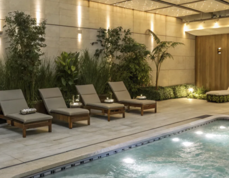 Modern luxury spa pool with in-pool lighting, wood accents, and ambient wall lights under a canopy of twinkling ceiling lights